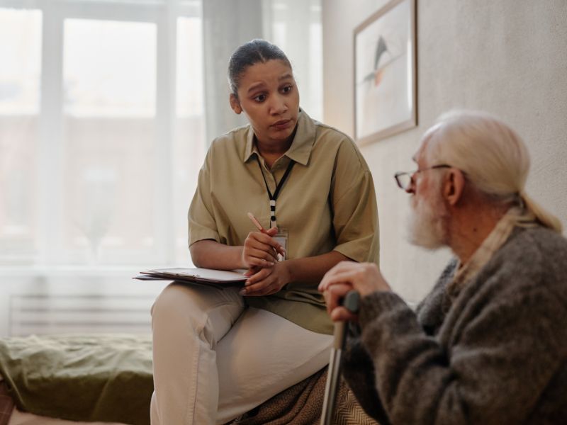 A representative consults an elderly man about the transition from home care to assisted living in Wisconsin